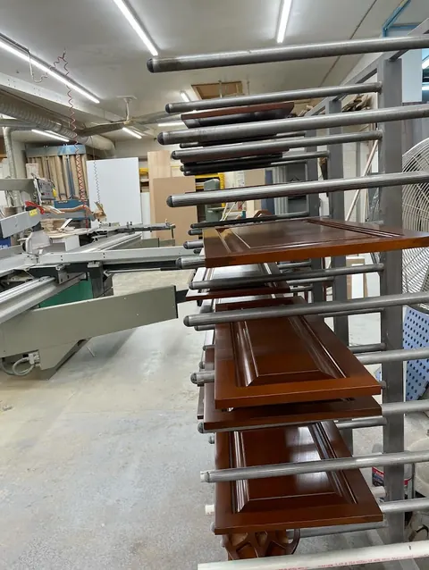 Portes d'armoires fraîchement vernies sur un chariot de séchage dans l'atelier